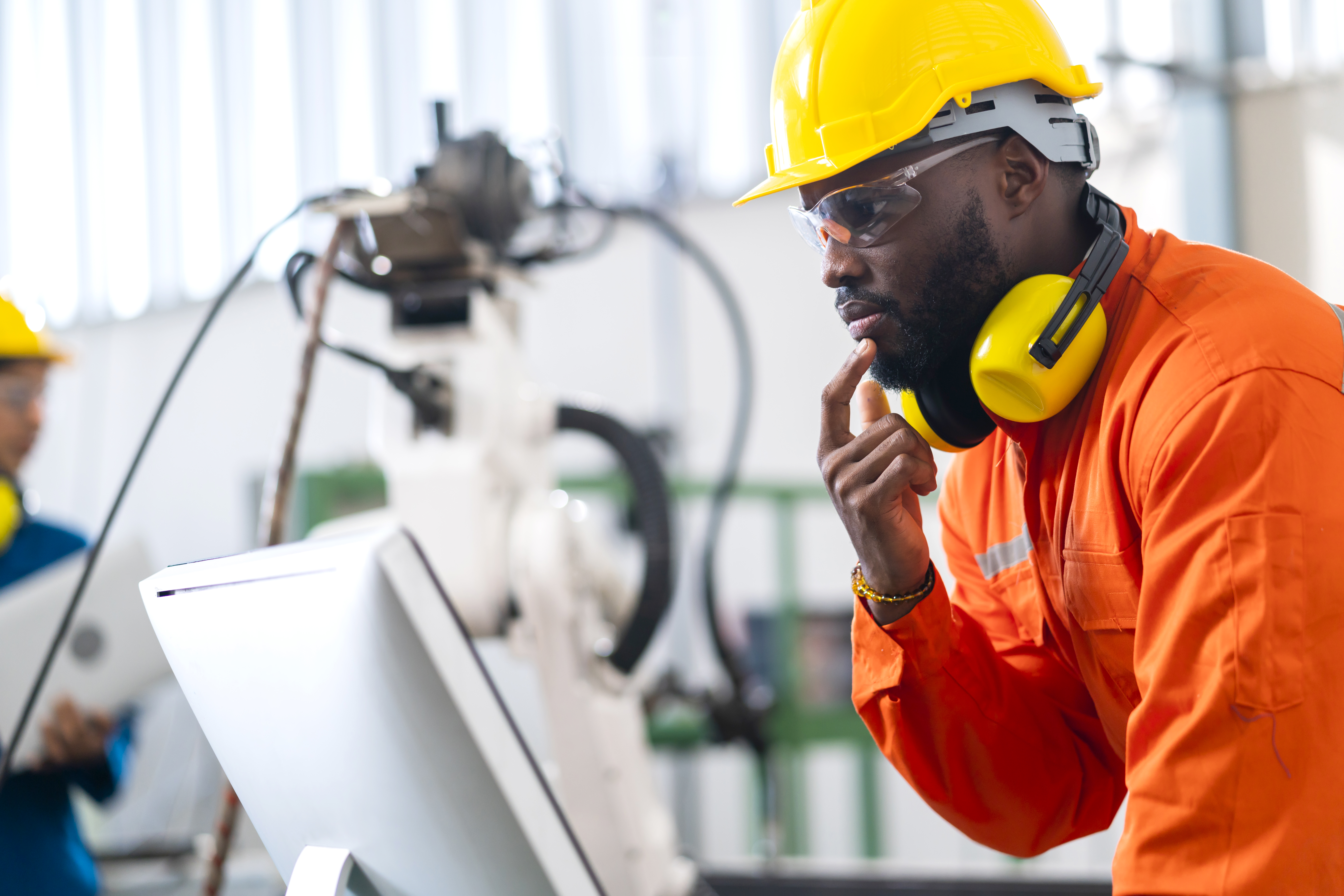 Engineer in a hard hat inspecting industrial equipment